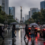 Avenida de la Ciudad de México con tráfico lento y cielo nublado durante una tarde de lluvia.